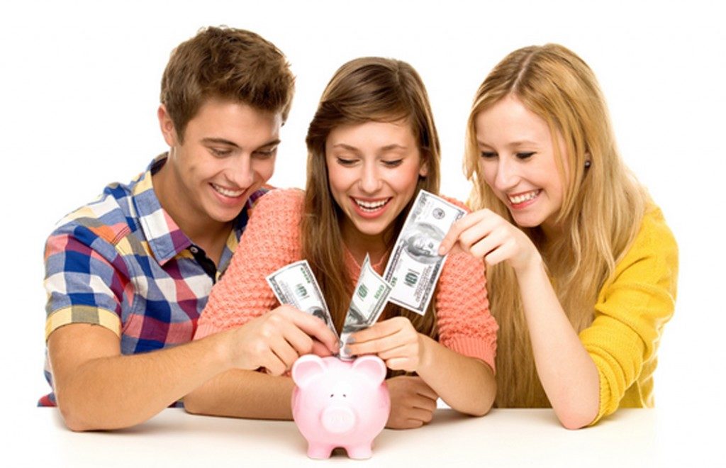 Teens putting money into a piggy bank